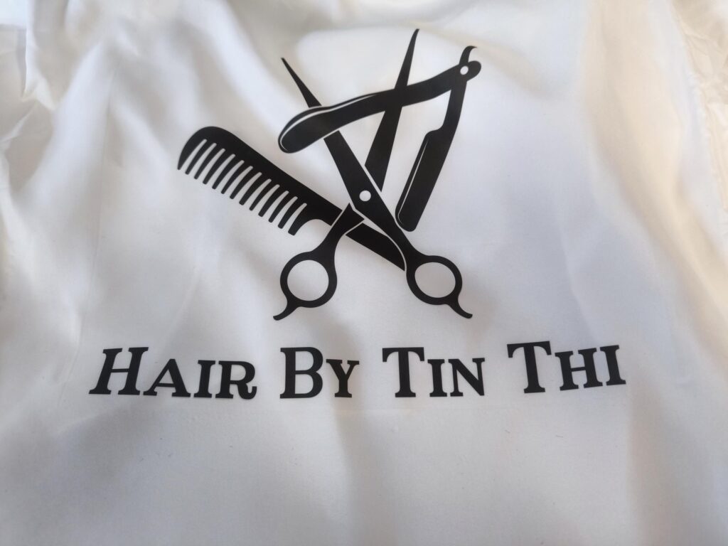 Hair Salon & Barber Cape with Pre-Designed Logo. Customizable Text for a Unique, Branded Look for Professional Stylists and Barbers.