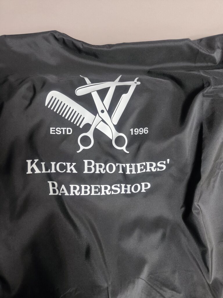 Hair Salon & Barber Cape with Pre-Designed Logo. Customizable Text for a Unique, Branded Look for Professional Stylists and Barbers.