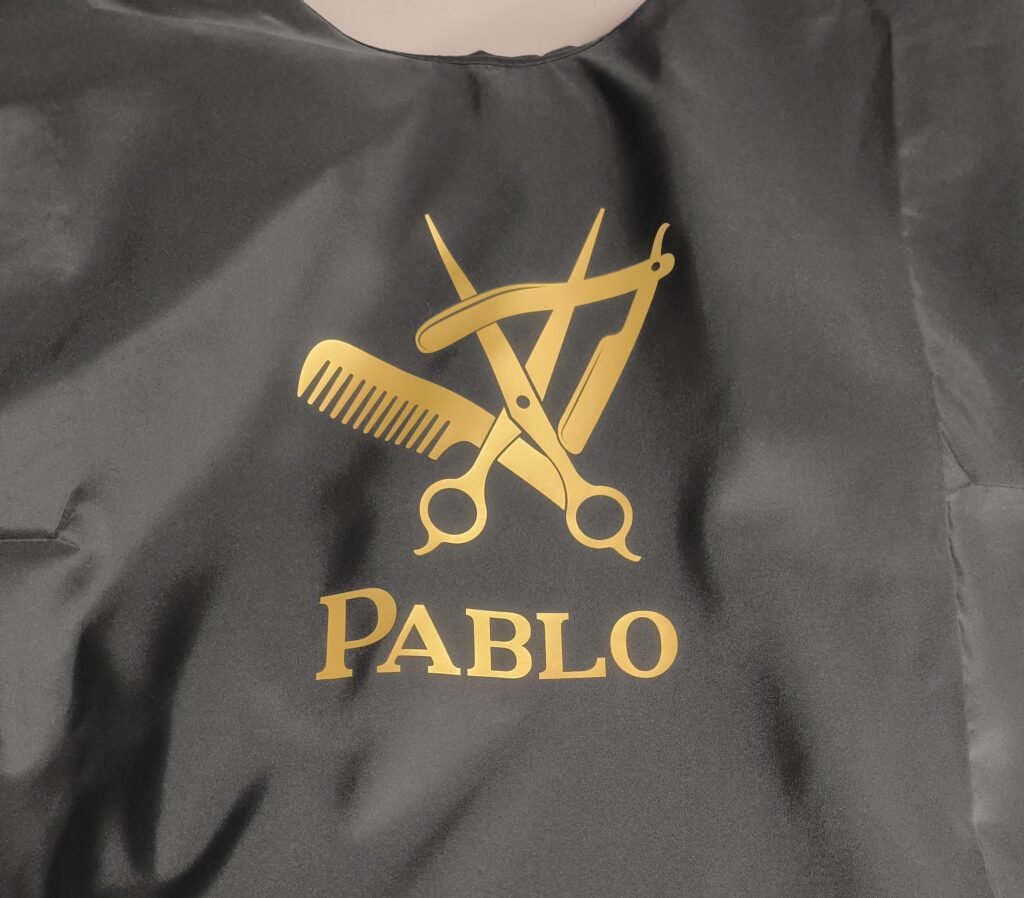 Hair Salon & Barber Cape with Pre-Designed Logo. Customizable Text for a Unique, Branded Look for Professional Stylists and Barbers.