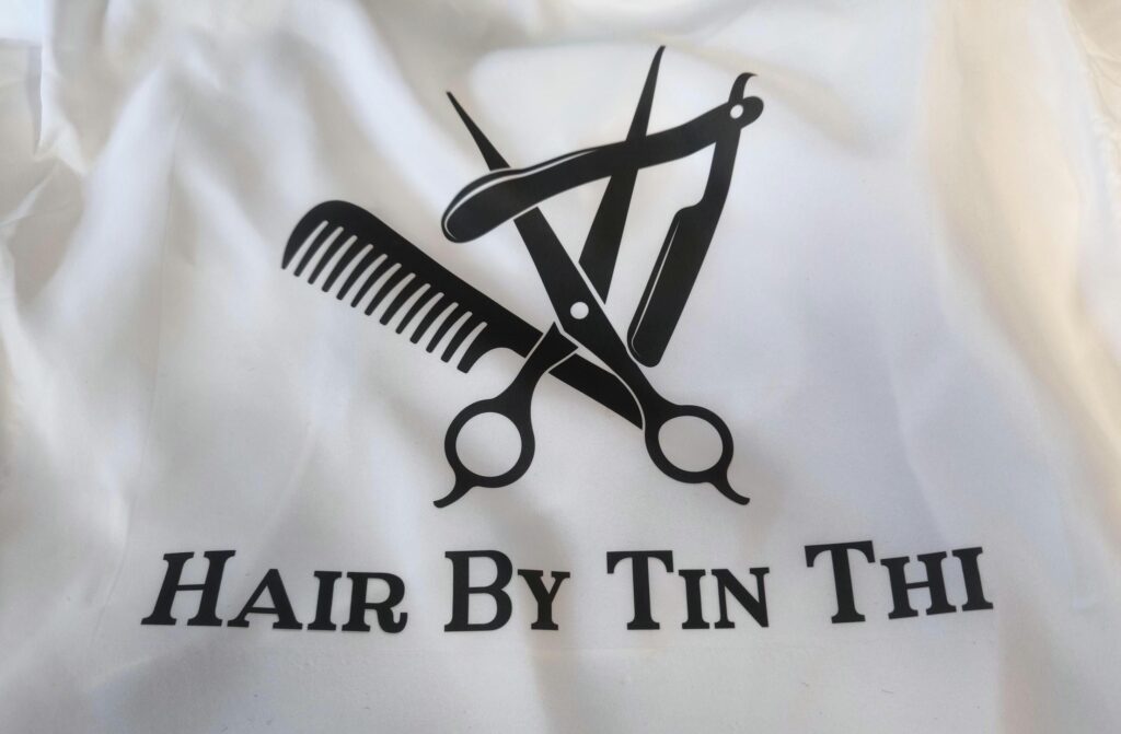 Hair Salon & Barber Cape with Pre-Designed Logo. Customizable Text for a Unique, Branded Look for Professional Stylists and Barbers.